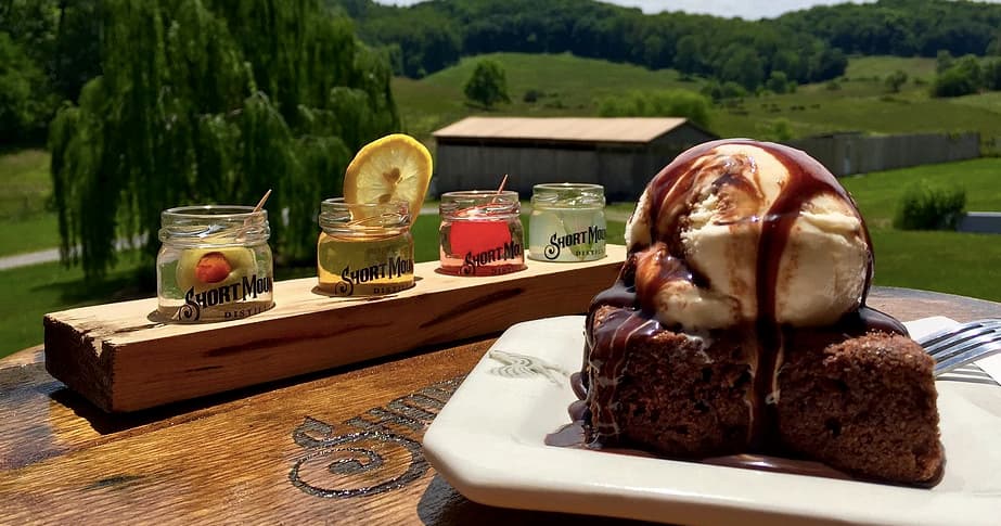 Outdoor tasting flight and dessert on rustic table with valley view