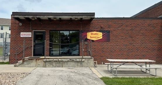 Front entrance ramp at brick shuttle service building, outdoor waiting area