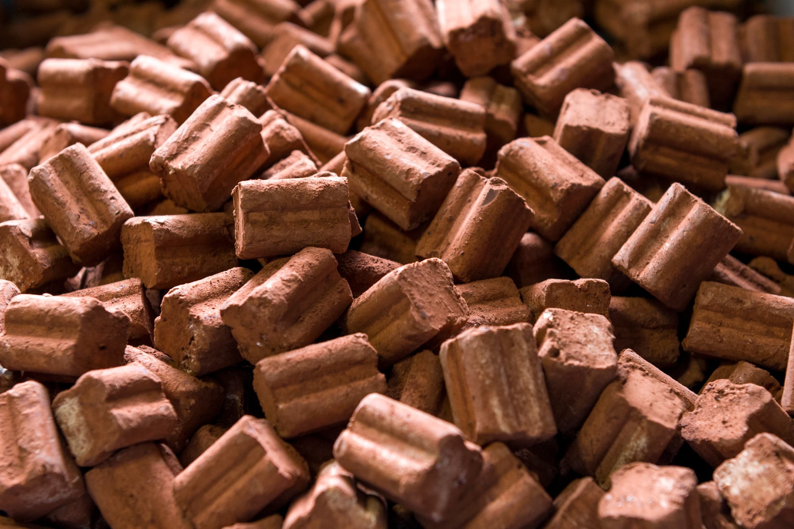 Artisan chocolate praline pieces piled in Turin workshop close-up