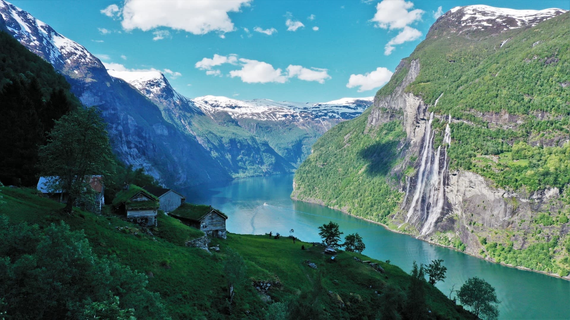 Panoramic fjord village and waterfalls framed by green mountains