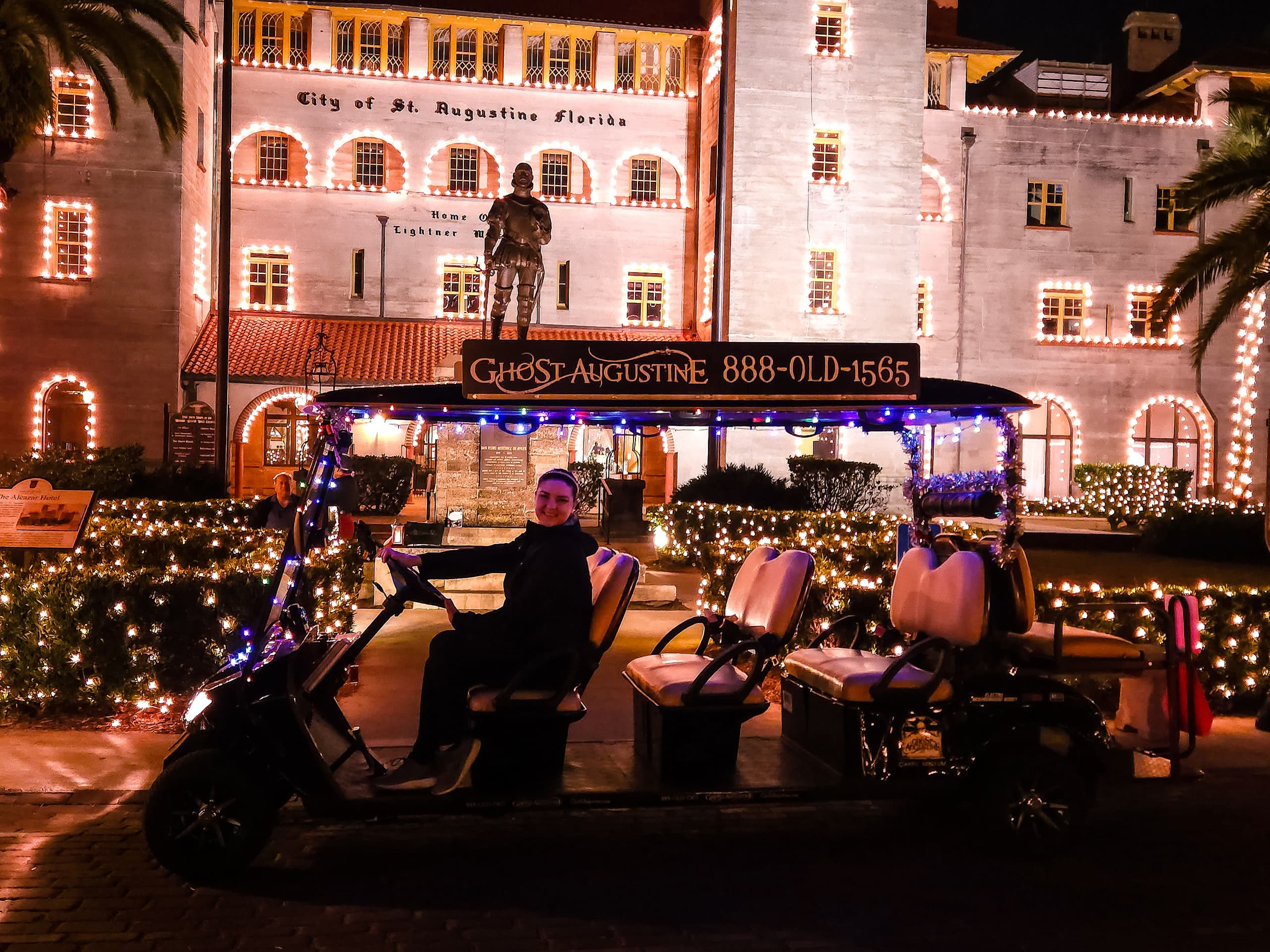 Illuminated historic St. Augustine hotel facade with trolley