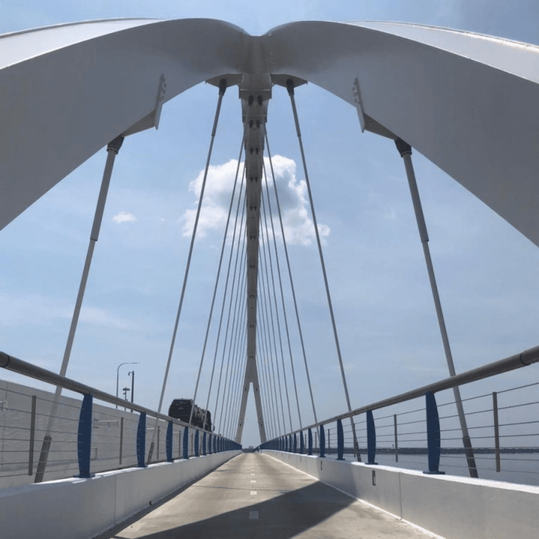 Modern pedestrian bridge walkway over water with clear sky