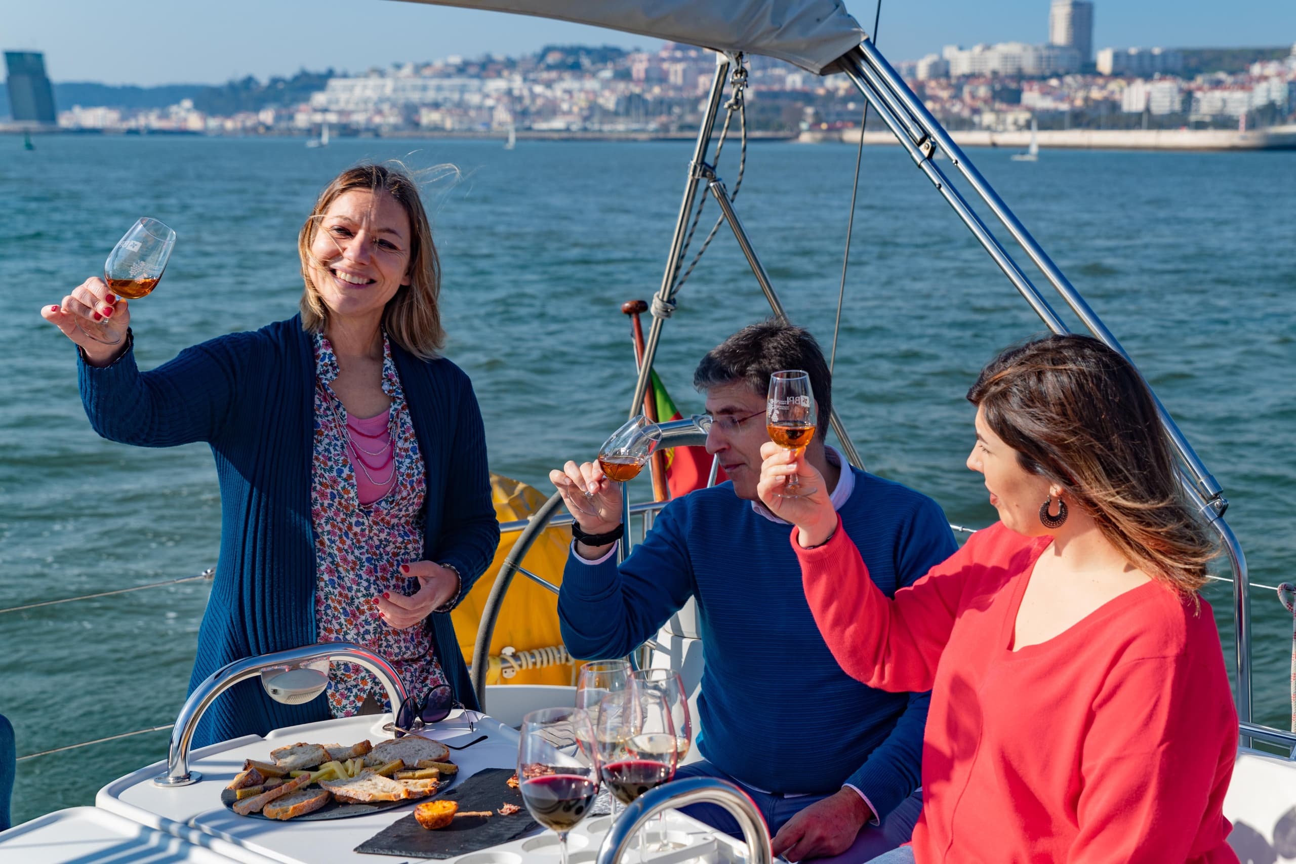 Group enjoying wine and snacks on sailing charter at sea