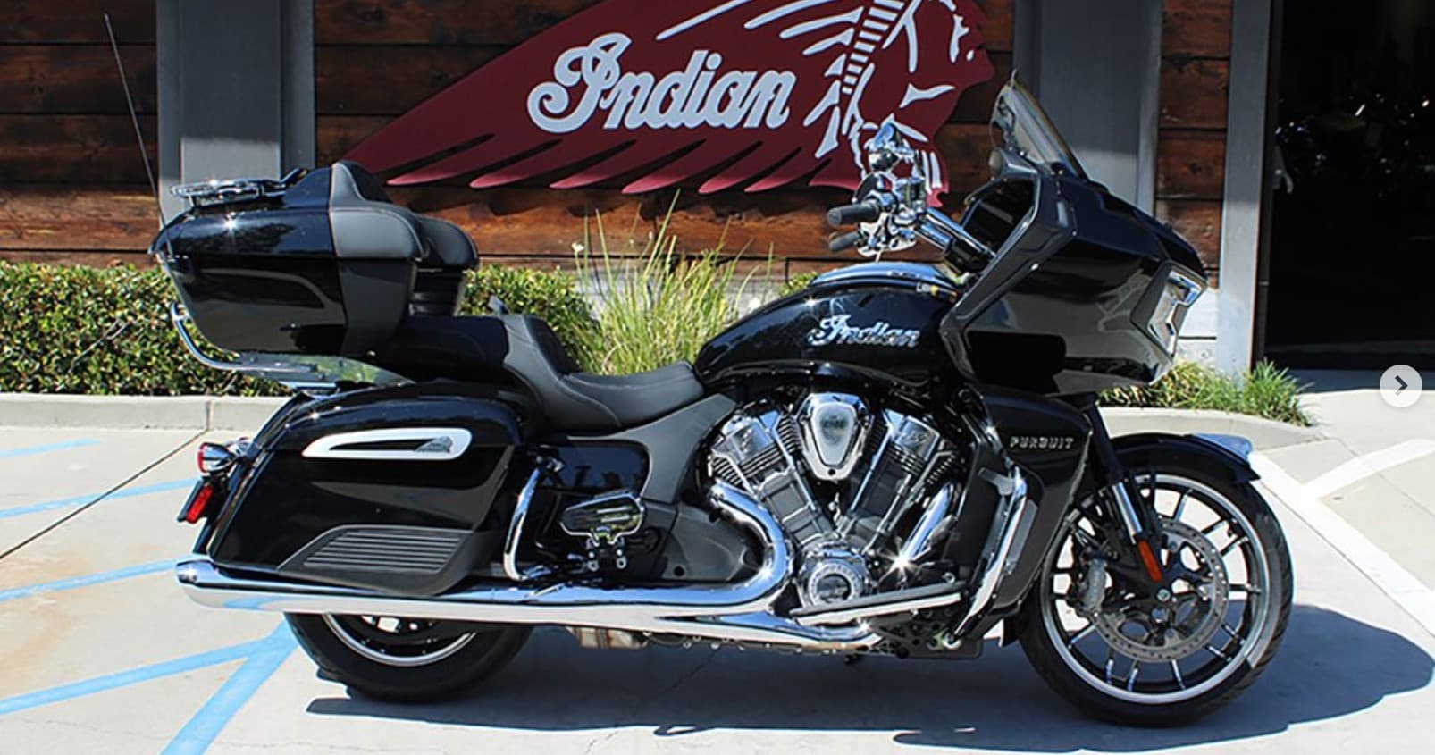 Black Indian touring motorcycle parked outside dealership lot
