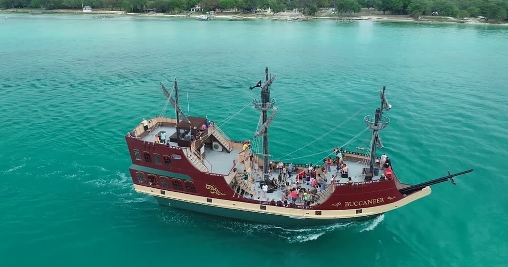 Red pirate ship cruising turquoise tropical ocean tour