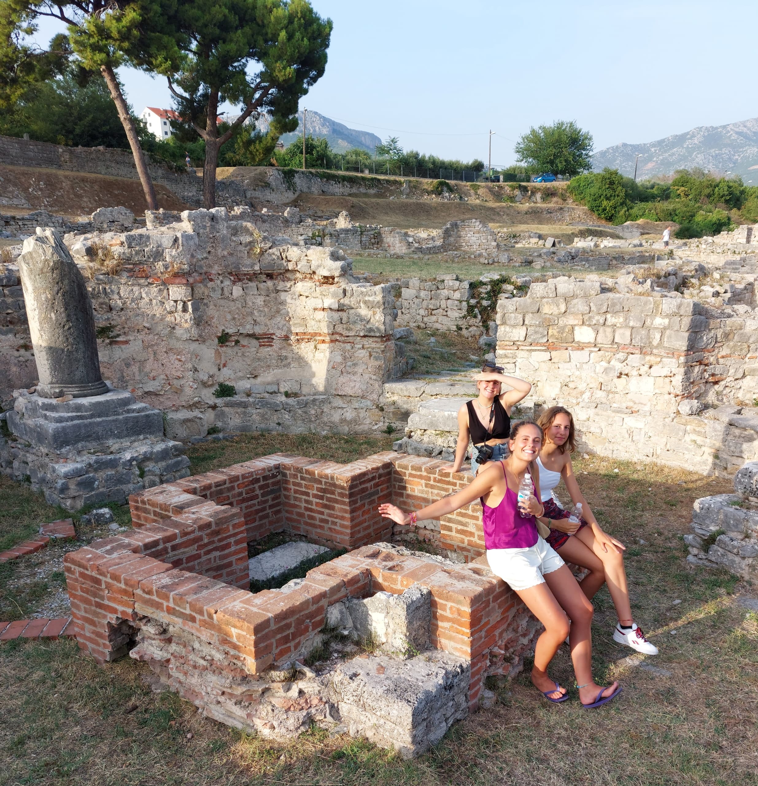 Tourists exploring ancient coastal ruins and brick foundations