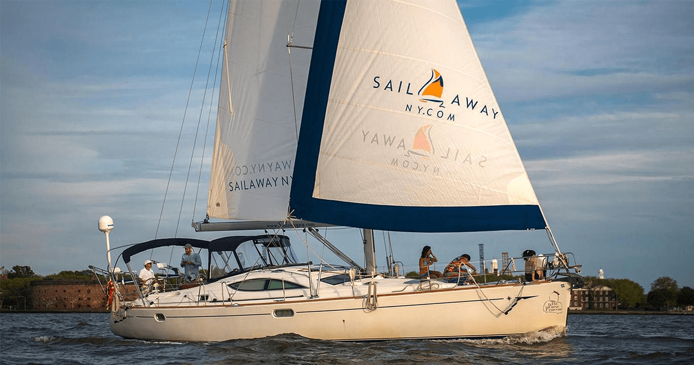 Sailboat cruising New York Harbor with passengers enjoying sail