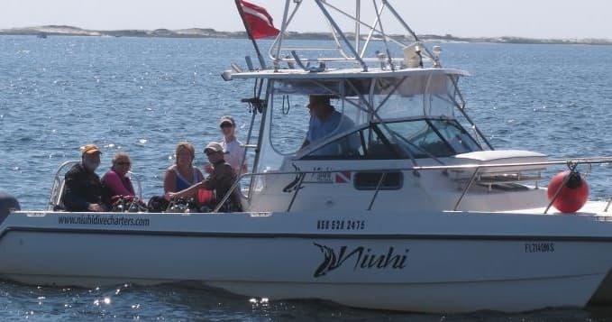 Charter dive boat with crew and divers on coastal sea trip