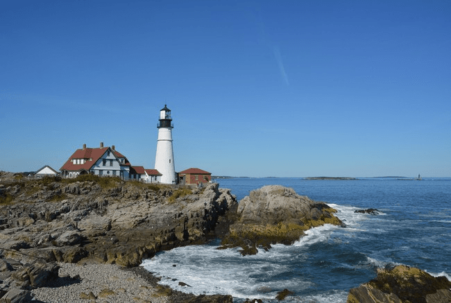 Iconic Portland Head Light on rugged coast under blue sky