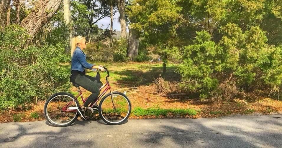 Cyclist riding along shaded coastal path on Edisto Island