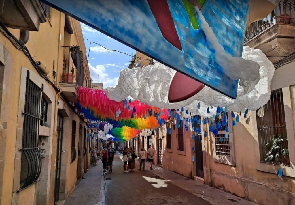Colorful street decorations in narrow Barcelona alley, festival stroll