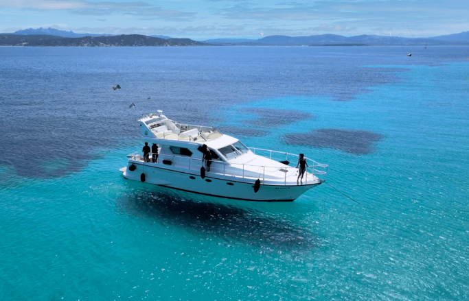 Motor yacht cruising turquoise Mediterranean waters, aerial view