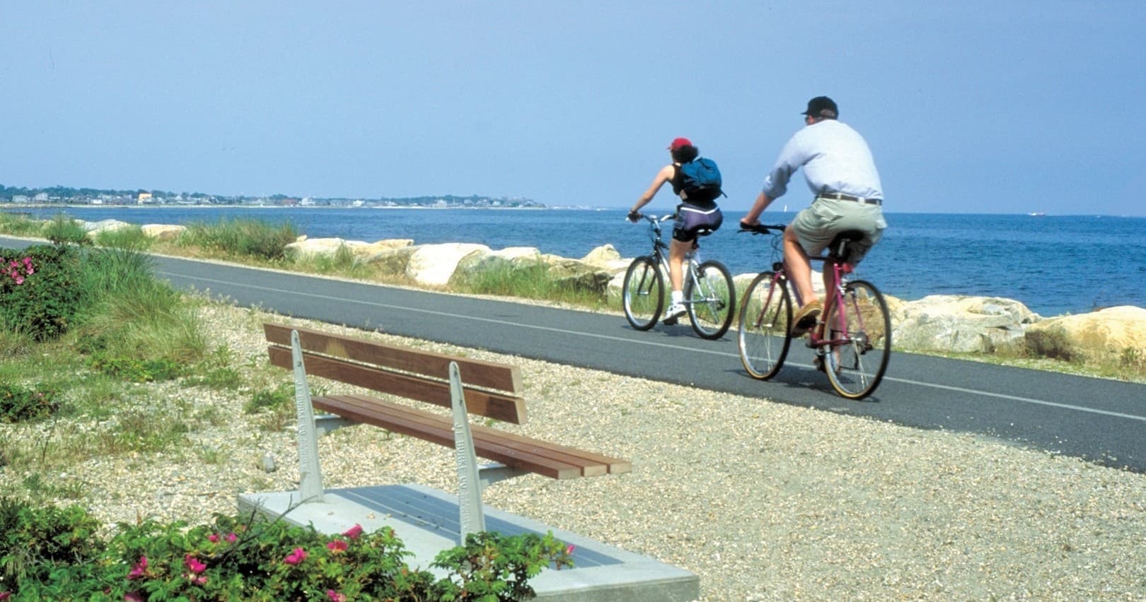 Bicyclists riding scenic coastal path by the ocean