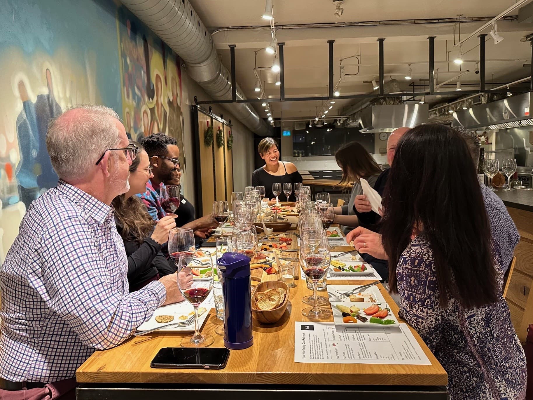 Group dining at communal table during indoor cooking tasting event