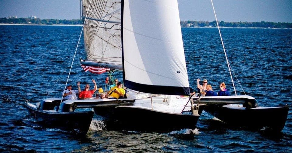 Sailing catamaran cruising open ocean with crew onboard