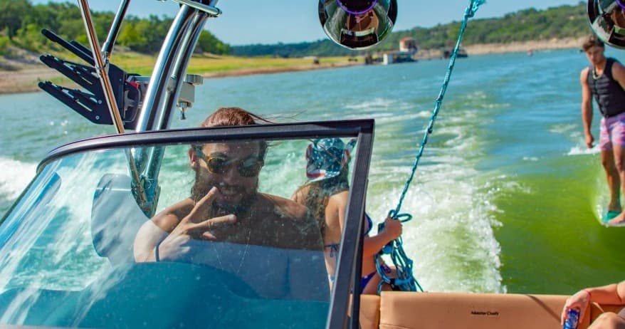 Driver and passengers cruising a lake boat during sunny day