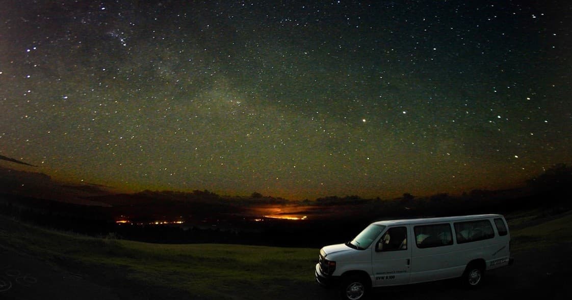 Camper van parked under starry sky on Maui coast