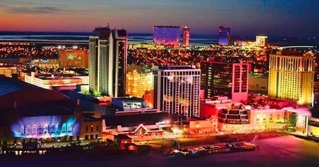 Nighttime Atlantic City skyline showing illuminated casinos on boardwalk