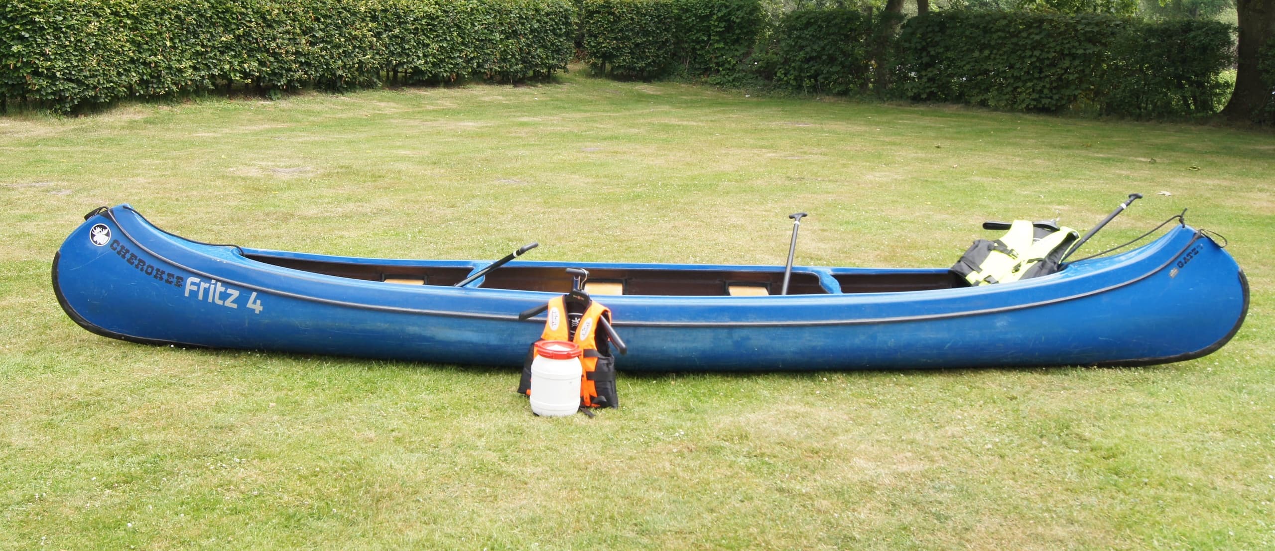 Blue tandem canoe with life jacket on lawn, staged for trip