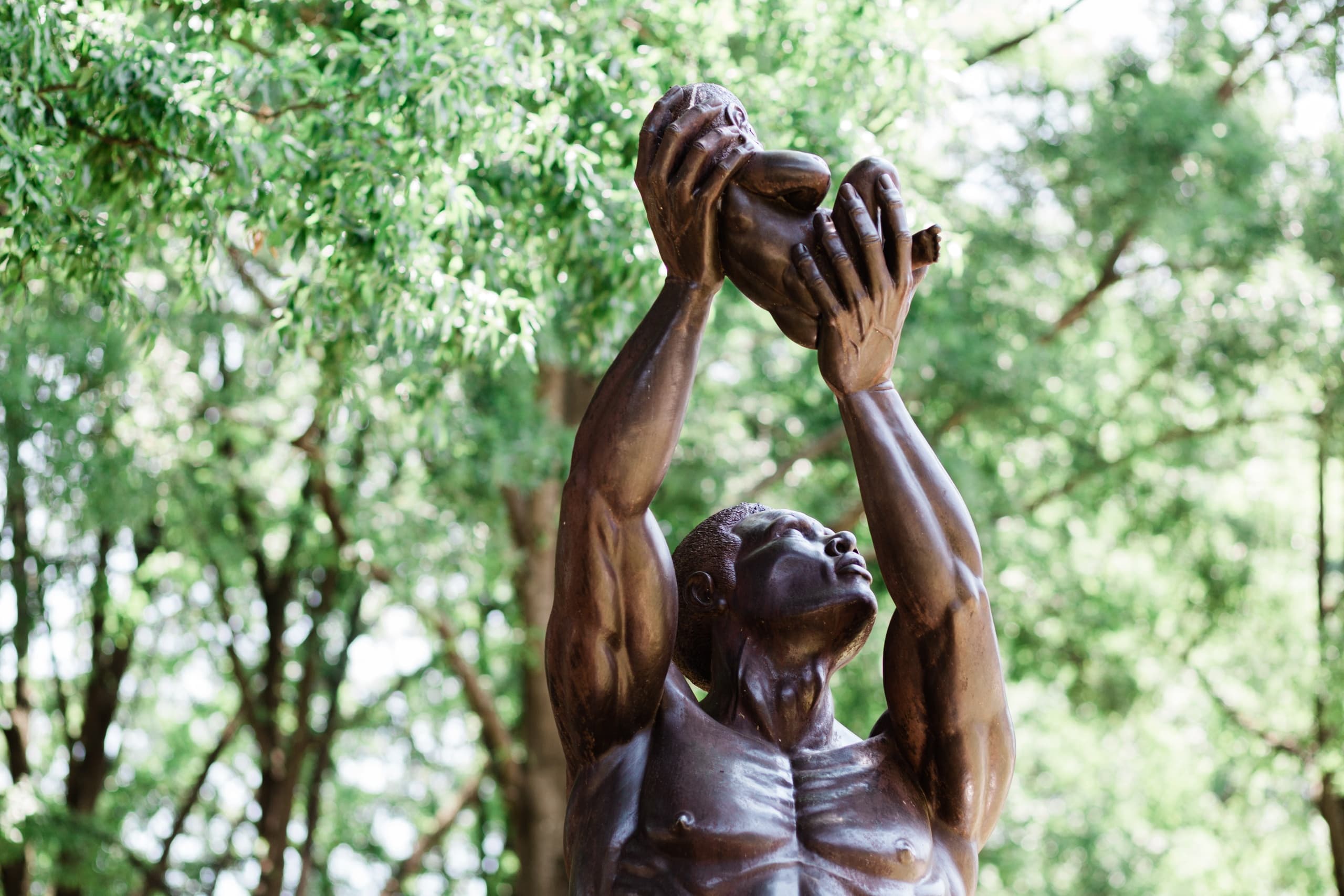 Outdoor bronze statue sculpture amid park trees in Atlanta