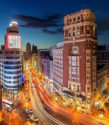 Urban night street with light trails and historic buildings
