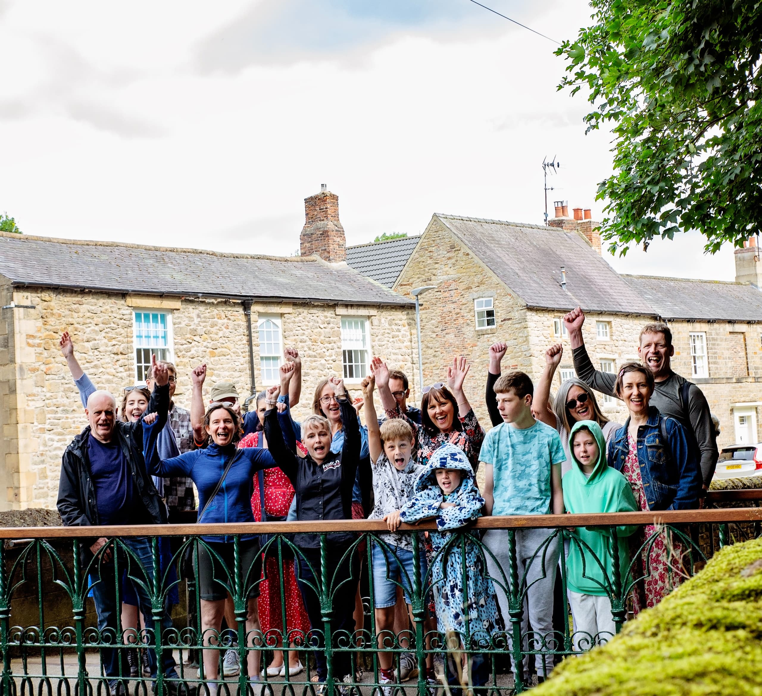 Group of walkers on stone bridge in English village outdoors
