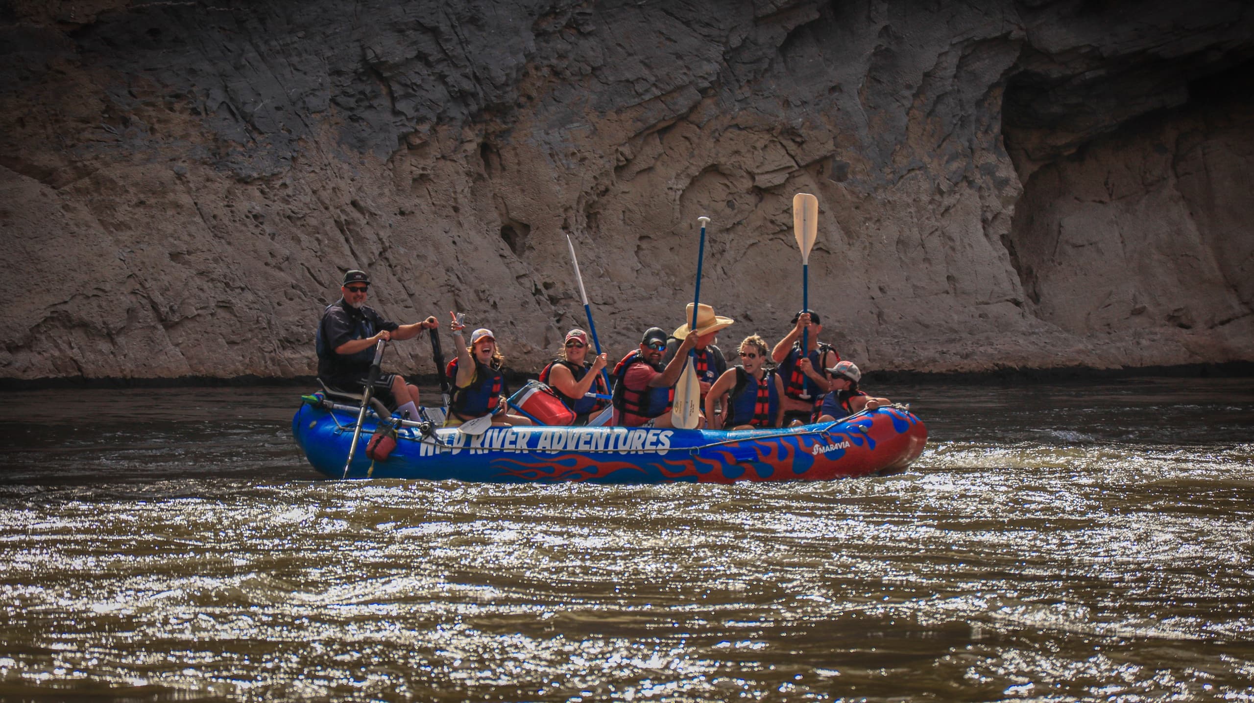 Guided raft trip with paddlers on scenic Idaho river canyon