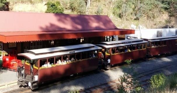Passengers boarding scenic vintage train at small rural railway station