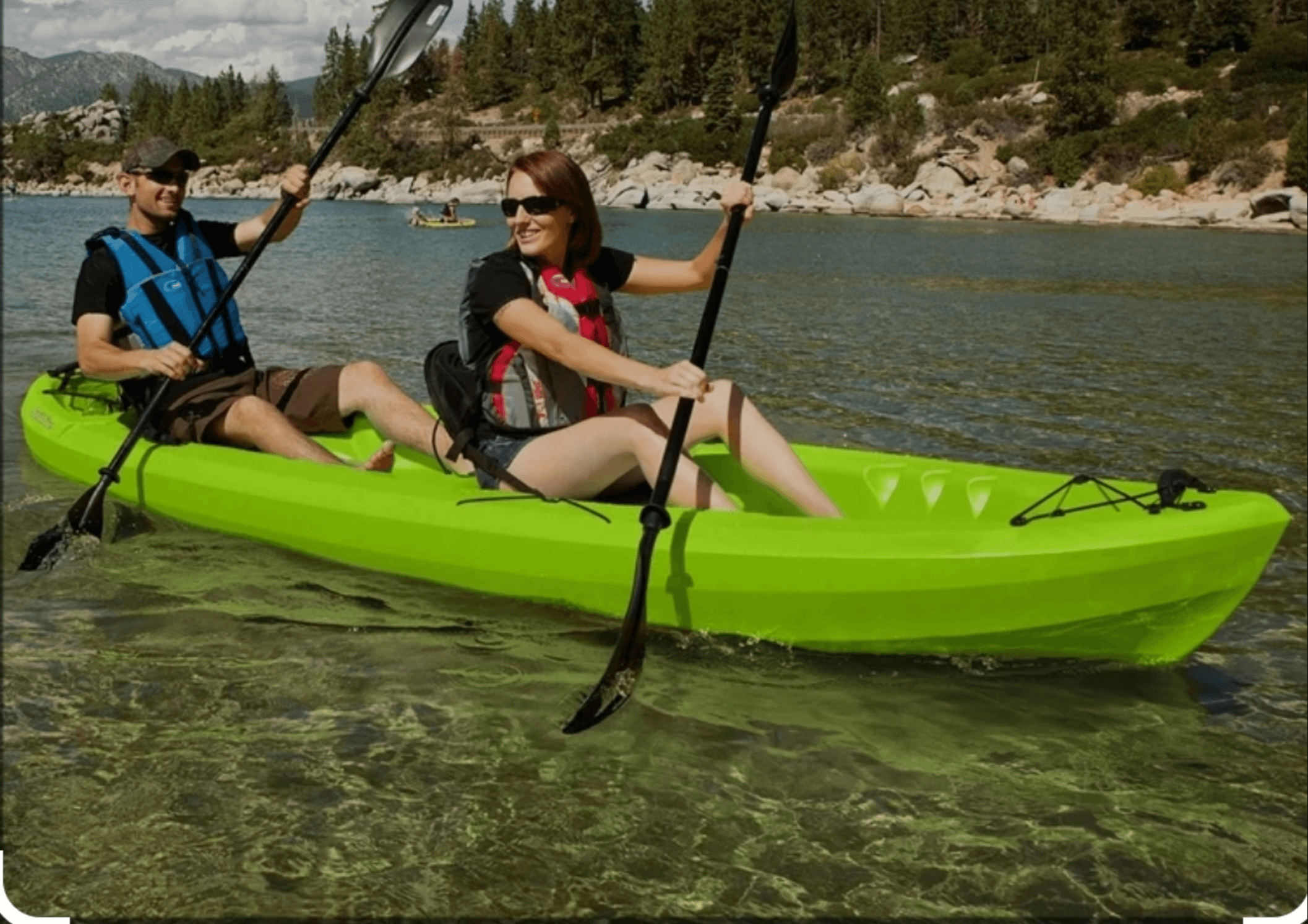 Couple kayaking in clear coastal bay, paddling near shore