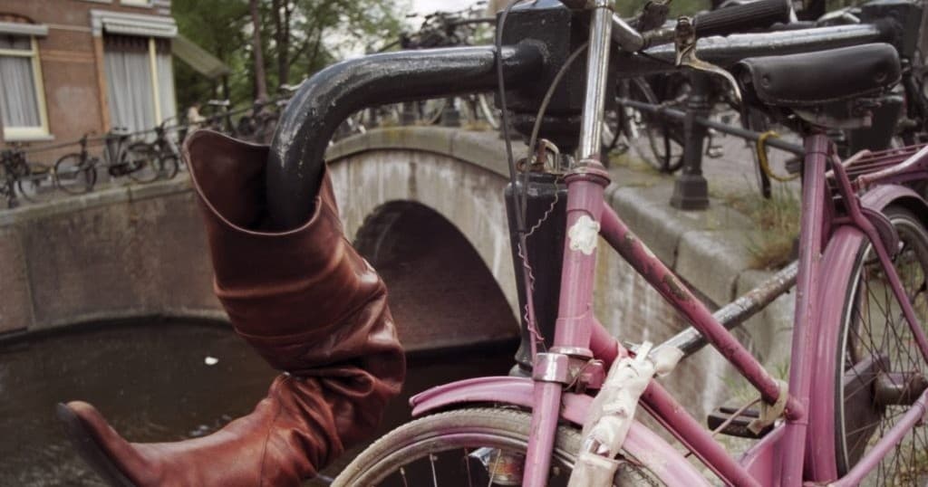 Cyclist boots by vintage bike on urban street cycling tour photo