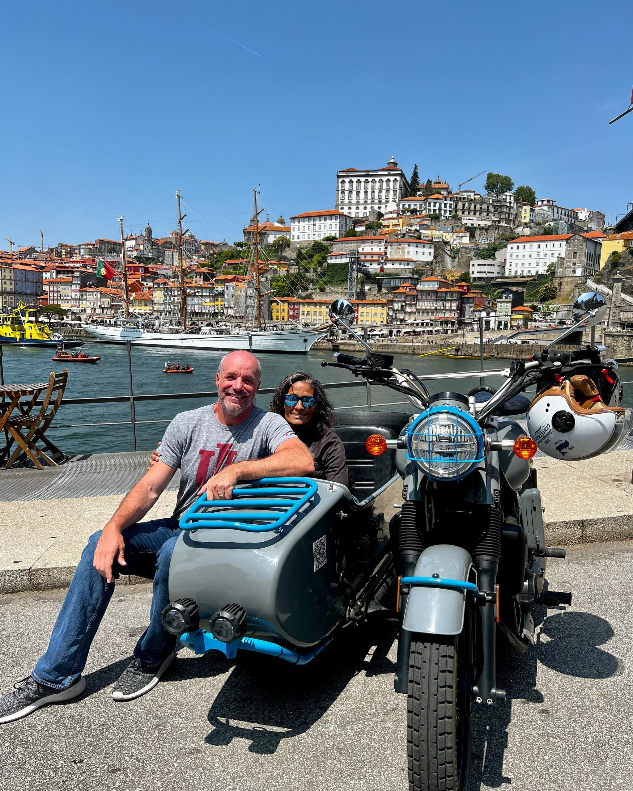 Couple with sidecar motorcycle by Porto waterfront cityscape