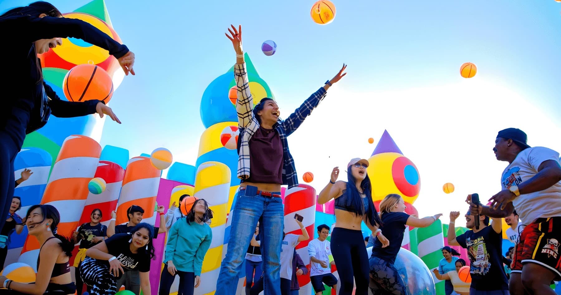 Group enjoying colorful outdoor inflatable festival with bouncing