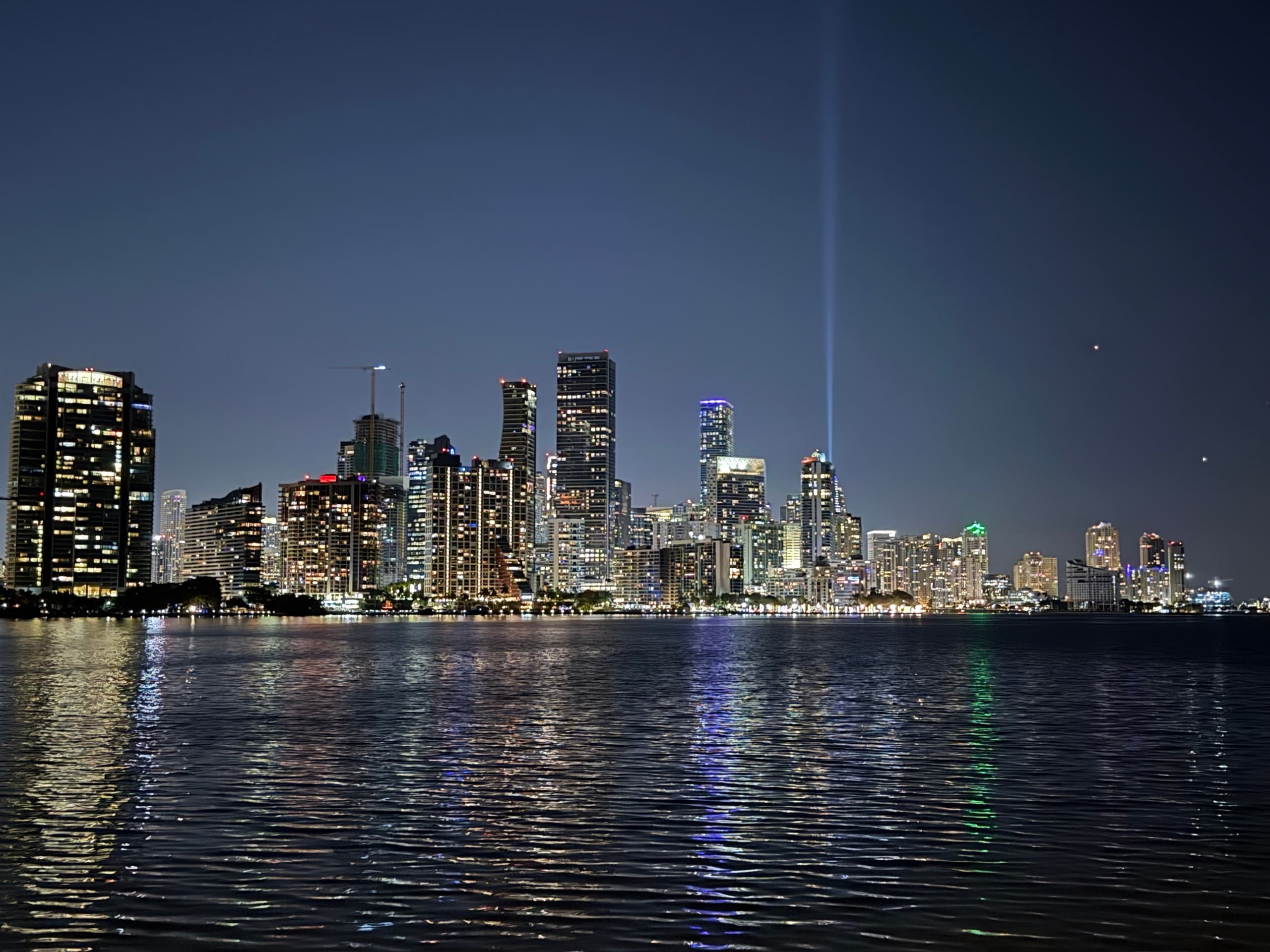 Nighttime Miami skyline reflecting on calm bay water