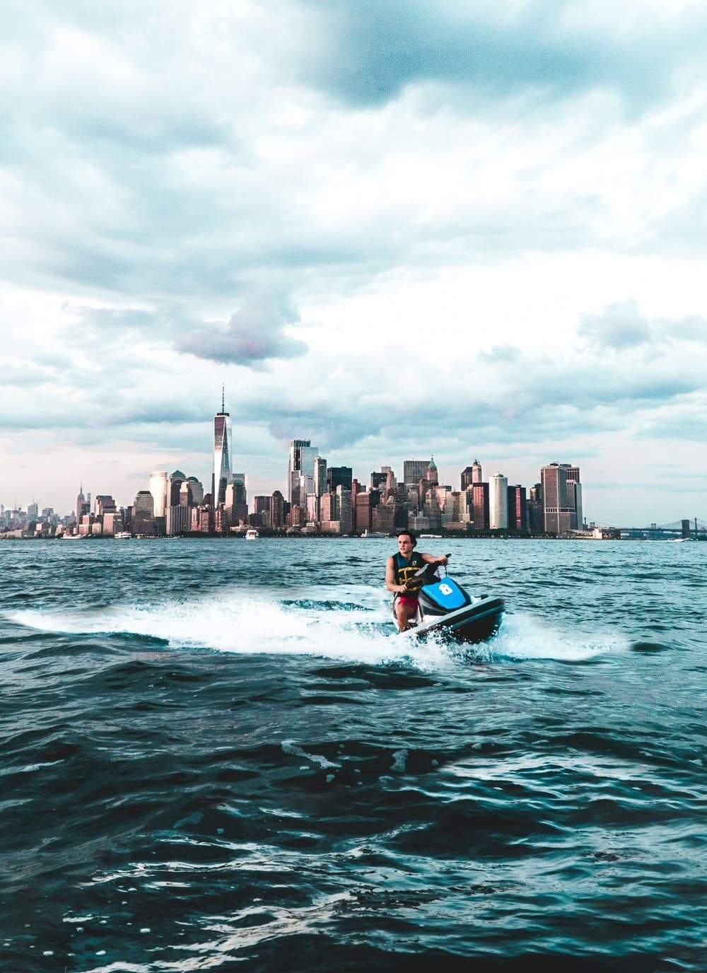 Jet skier speeding across Manhattan skyline at sunset