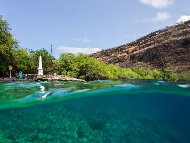 Split-view tropical coast with clear turquoise water and kayakers
