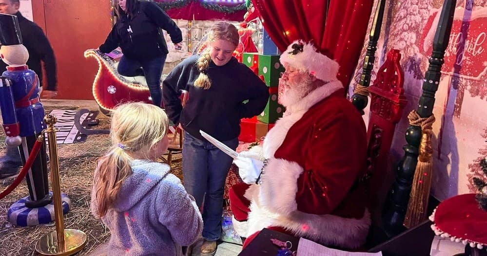 Kids meeting Santa at indoor holiday display with festive décor