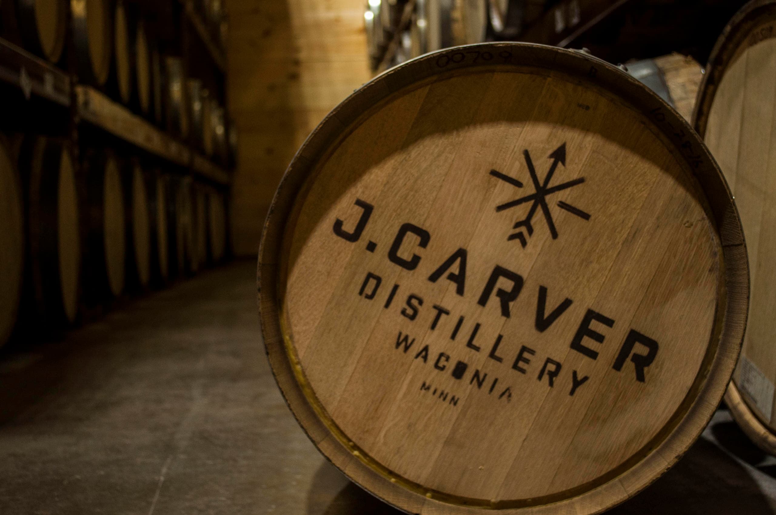 Barrel cellar aisle in distillery showing aged oak barrels