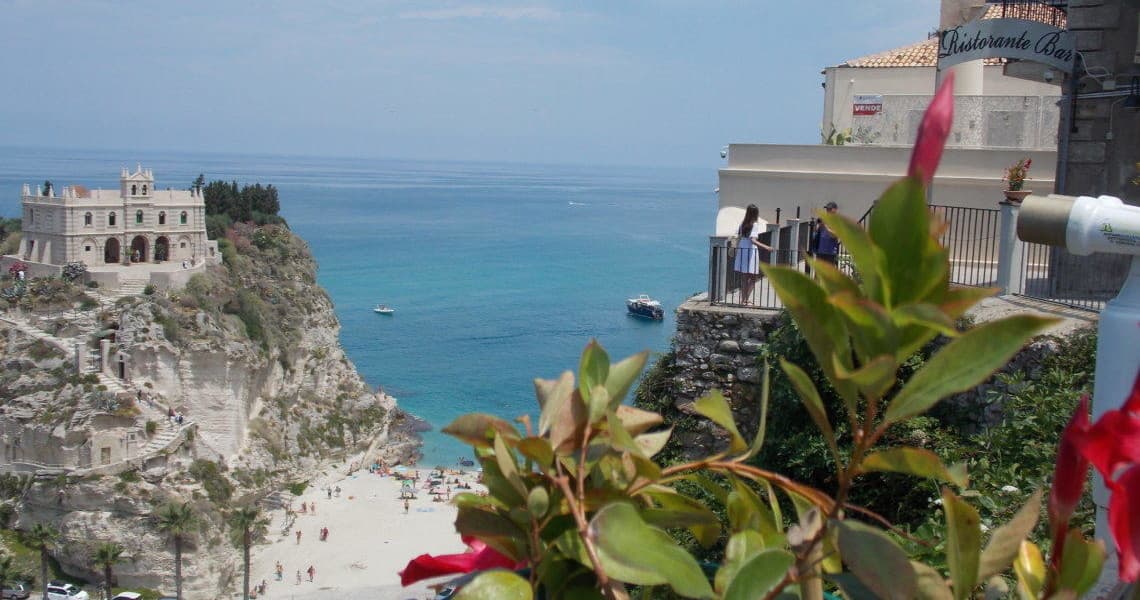 Cliffside beach view with tourists and Mediterranean sea