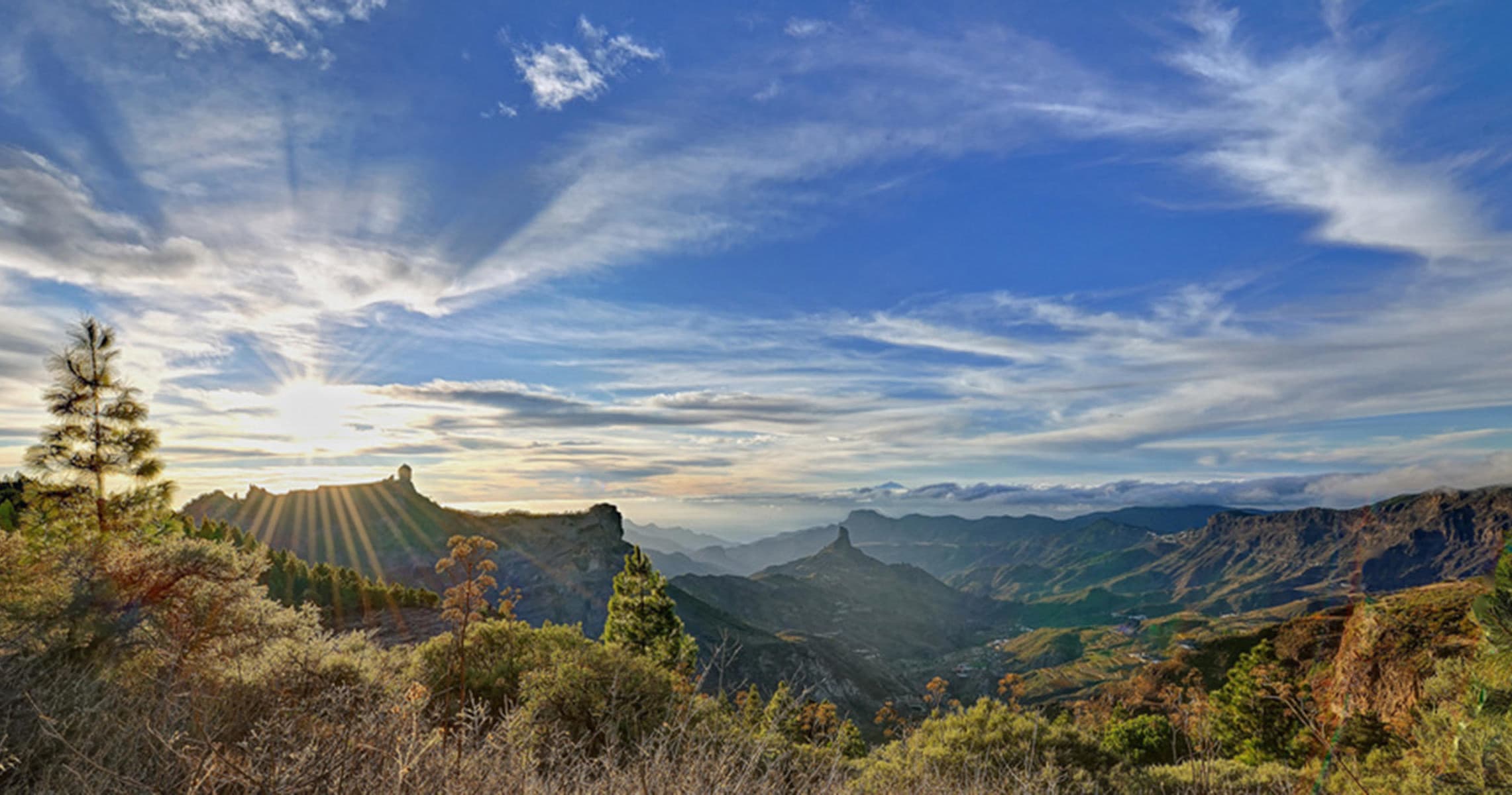 Panoramic mountain sunrise over volcanic canyon hiking vista