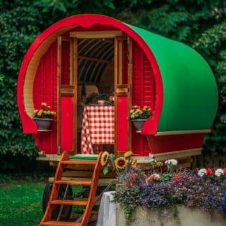 Colorful gypsy caravan parked in leafy woodland campsite