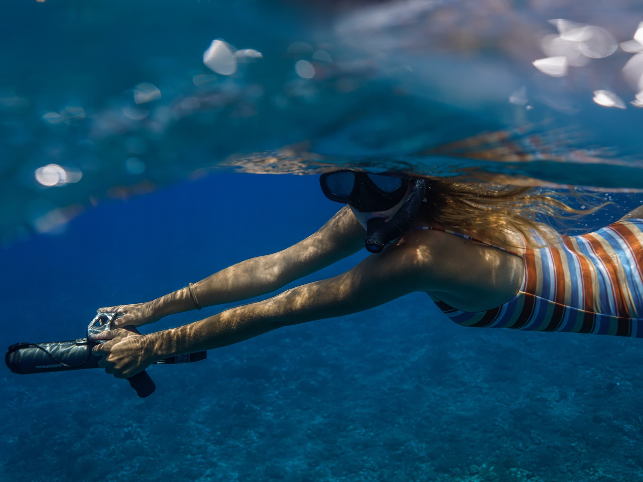 Freediver snorkeling with fins in clear Lanai ocean waters