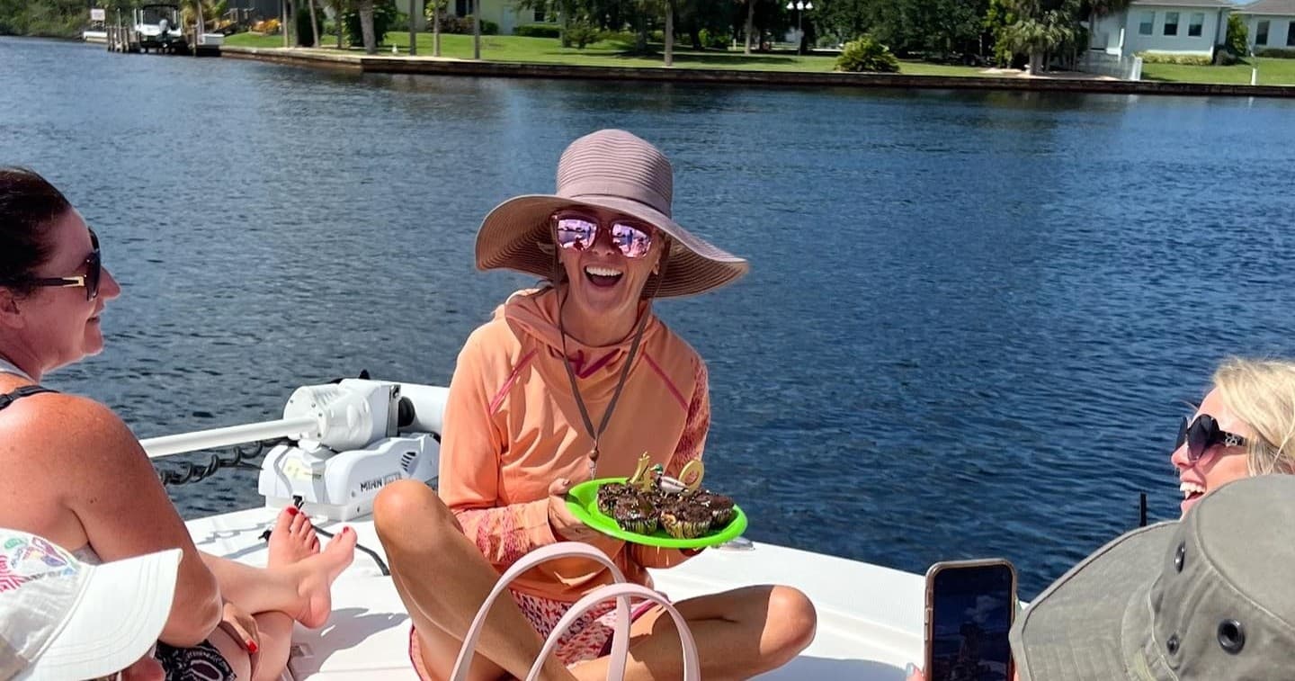 Friends laughing on bow of boat during sunny inland water cruise