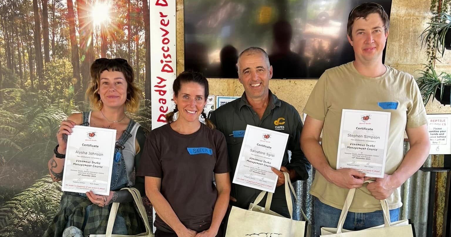 Staff and graduates posing at indoor wildlife education event