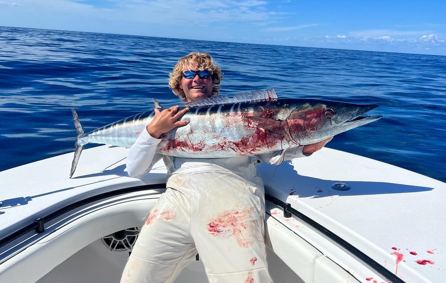 Angler with large tuna on boat bow, offshore big game fishing