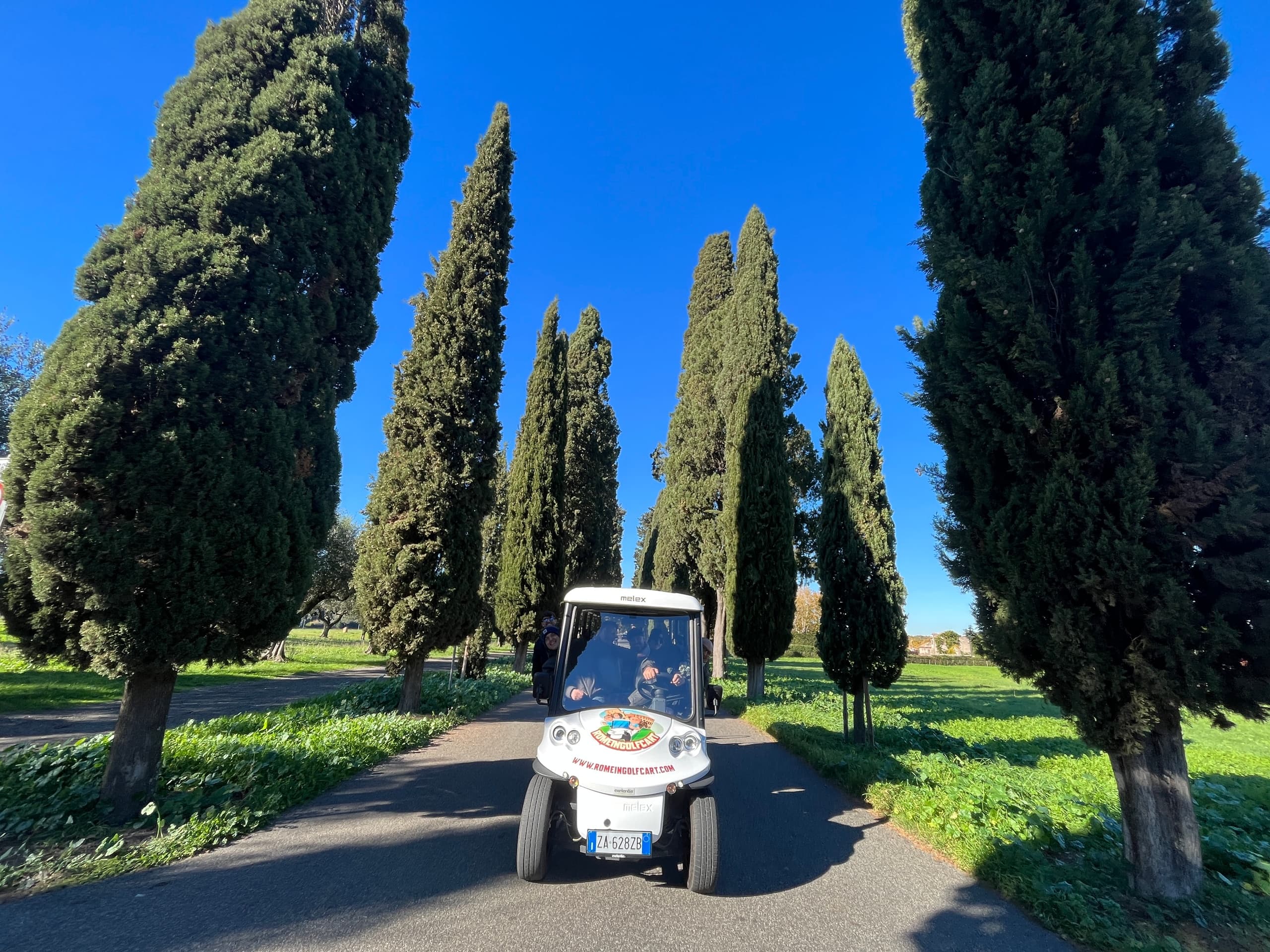 Small electric cart on scenic cypress avenue near Rome