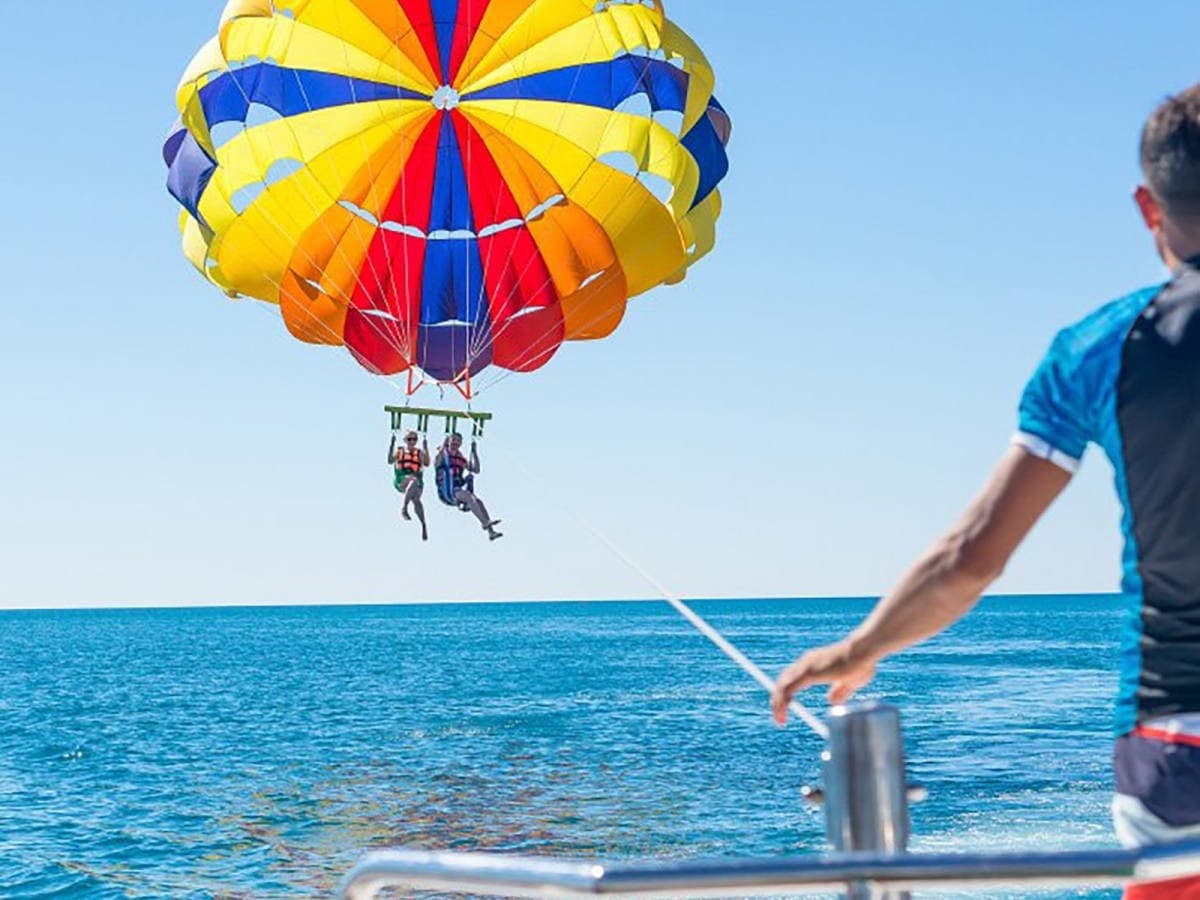 Bright parasail over deep blue sea with rider enjoying flight