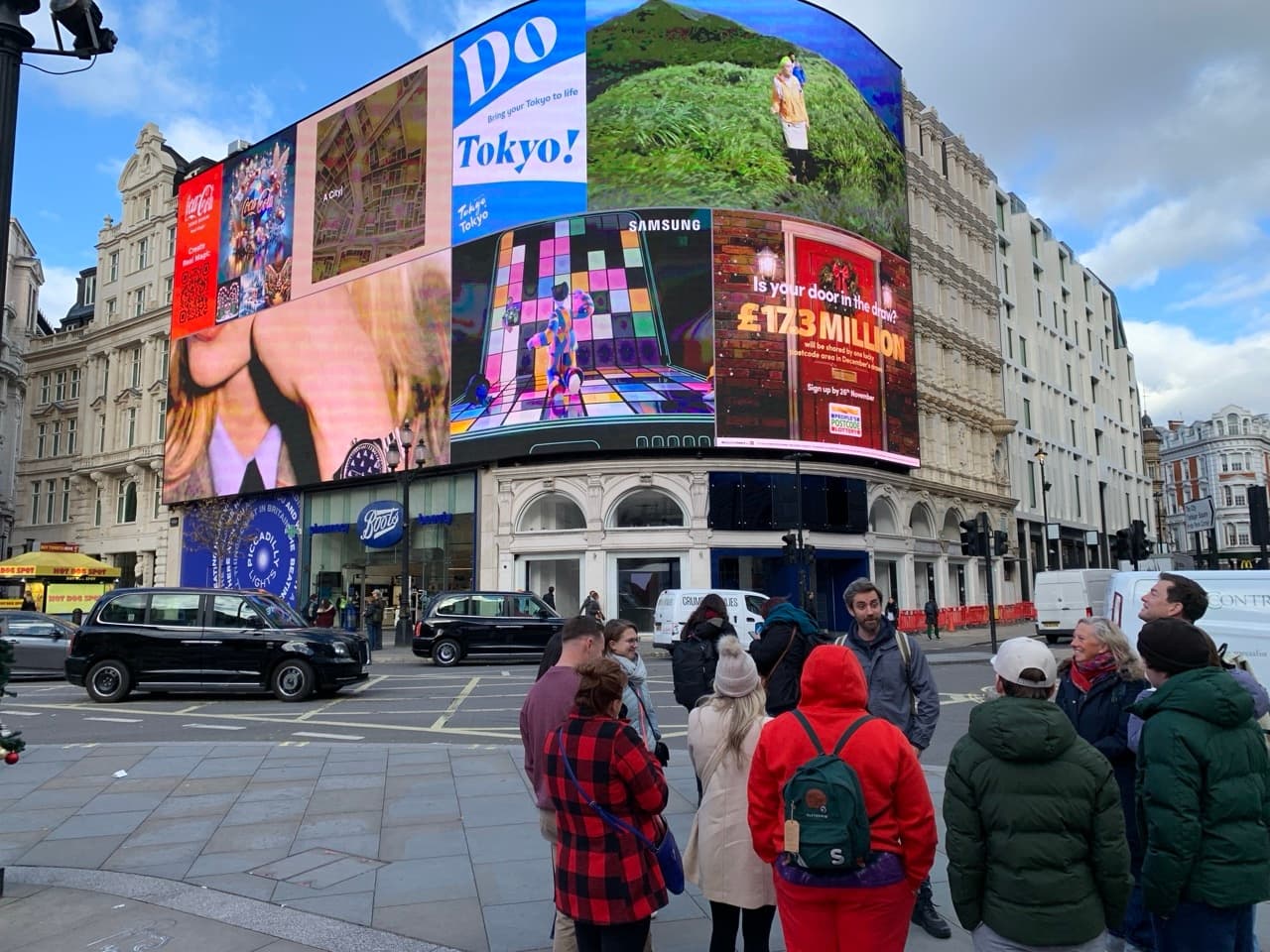 Bustling Piccadilly Circus street scene with guided walking tour crowds