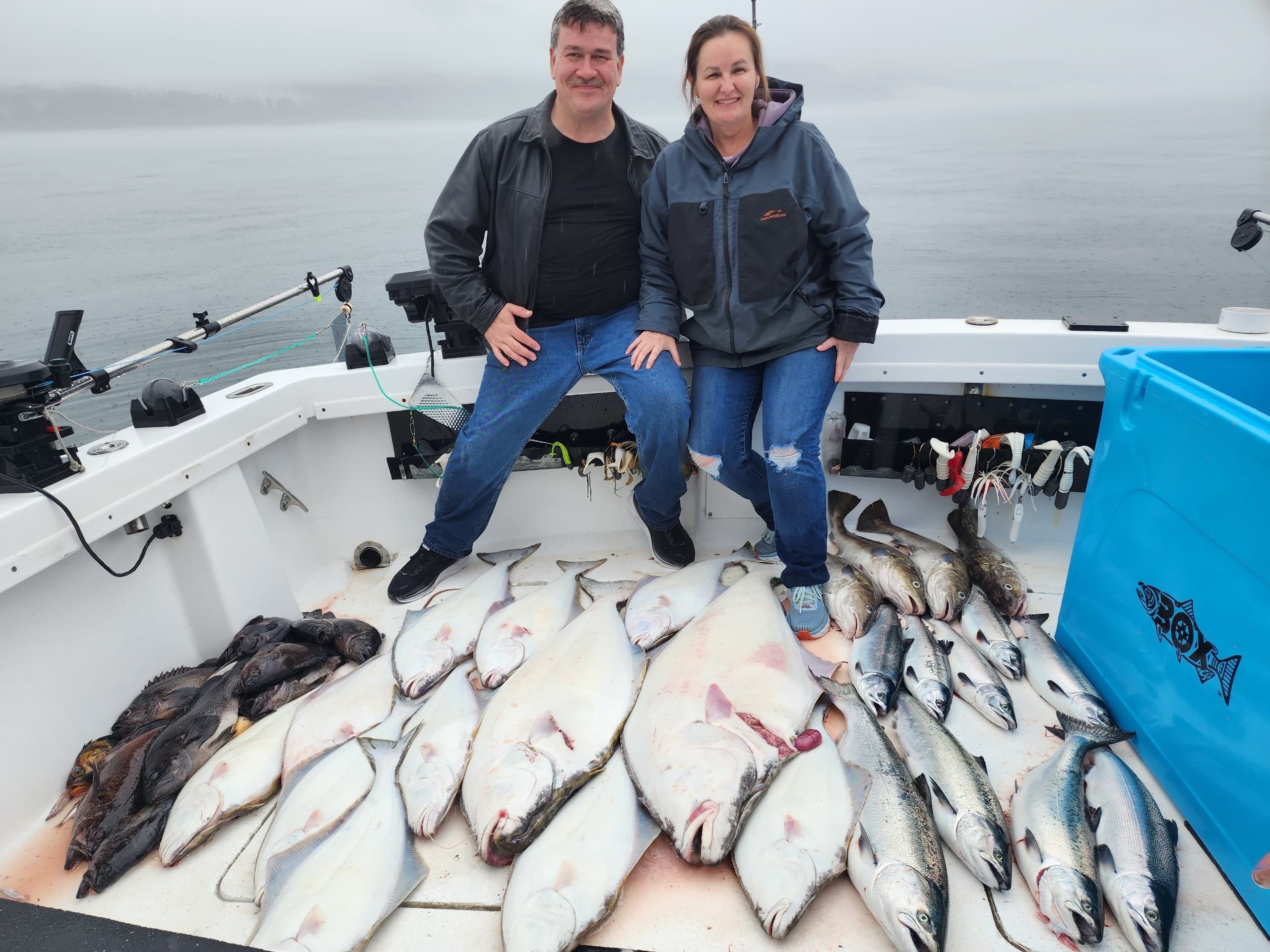 Couple on fishing charter with halibut and salmon on boat