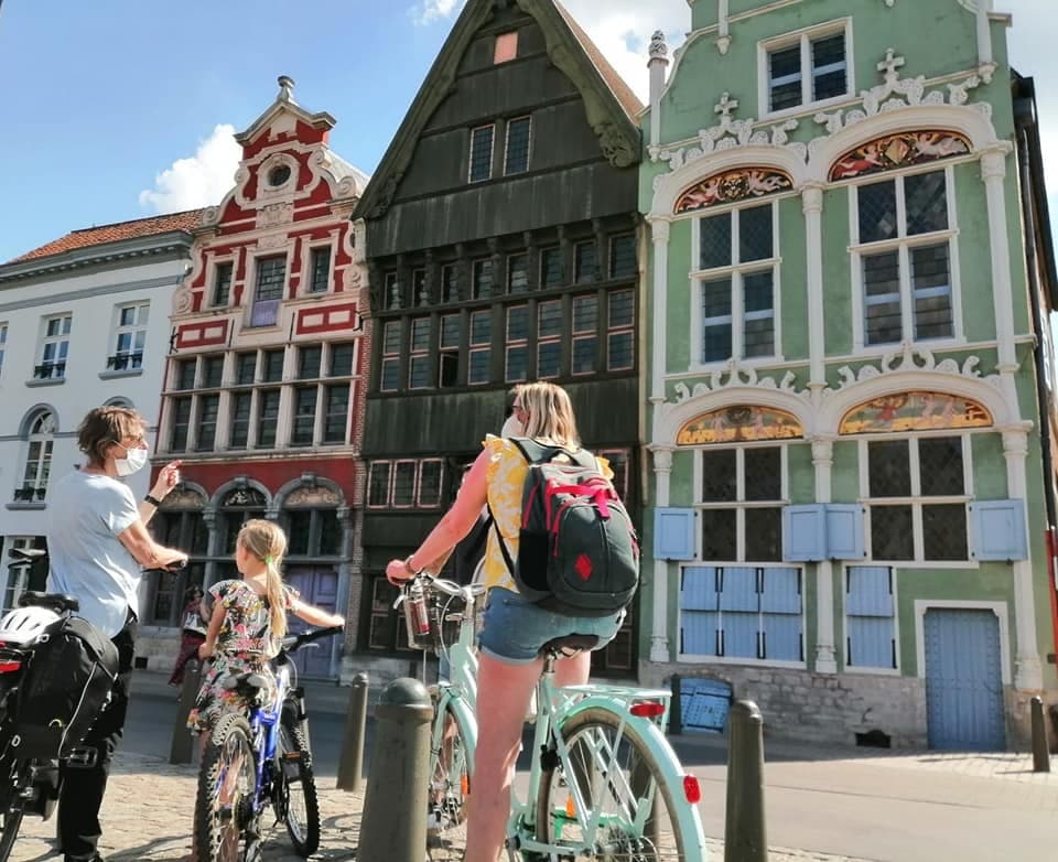 Cyclists exploring colorful historic market buildings on city tour