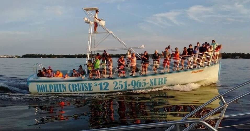 Dolphin cruise tour boat with passengers on ocean deck